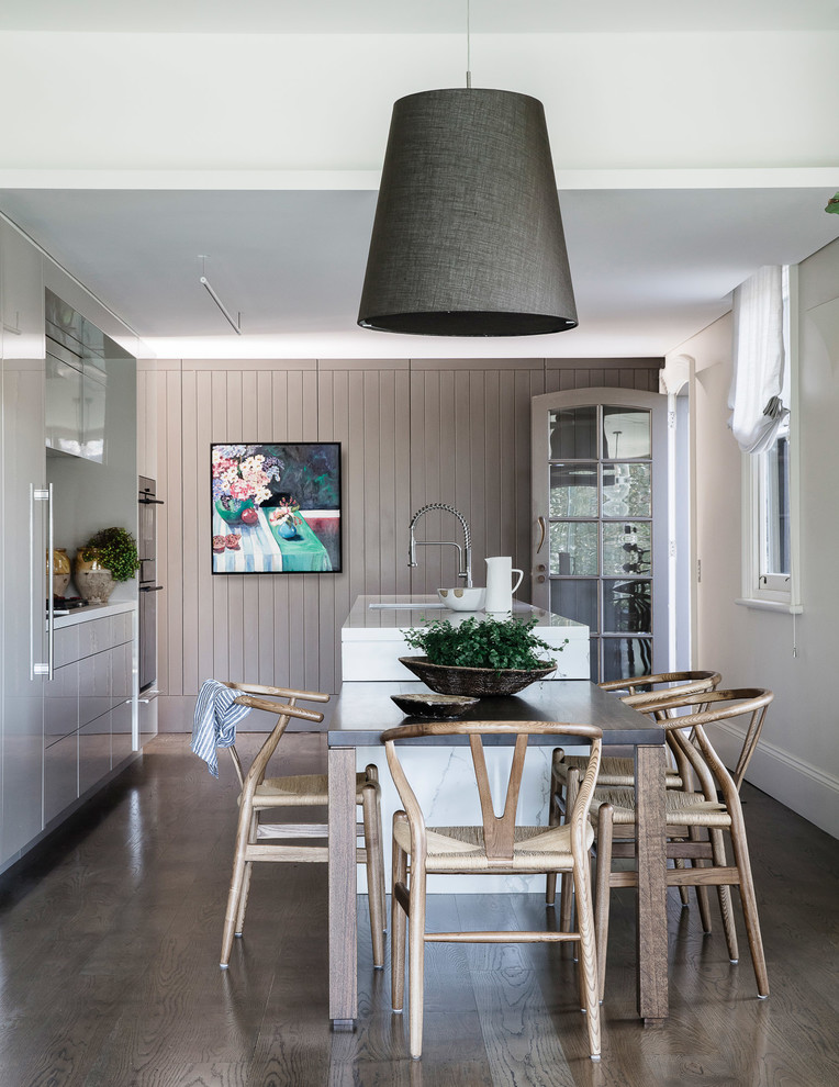 Inspiration for a timeless galley dark wood floor eat-in kitchen remodel in Sydney with an undermount sink, flat-panel cabinets, gray cabinets, black appliances, an island and white countertops
