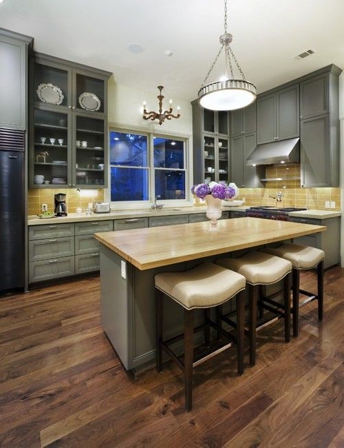 Mid-sized farmhouse l-shaped dark wood floor eat-in kitchen photo in New York with an undermount sink, recessed-panel cabinets, gray cabinets, wood countertops, yellow backsplash, glass tile backsplash, stainless steel appliances and an island