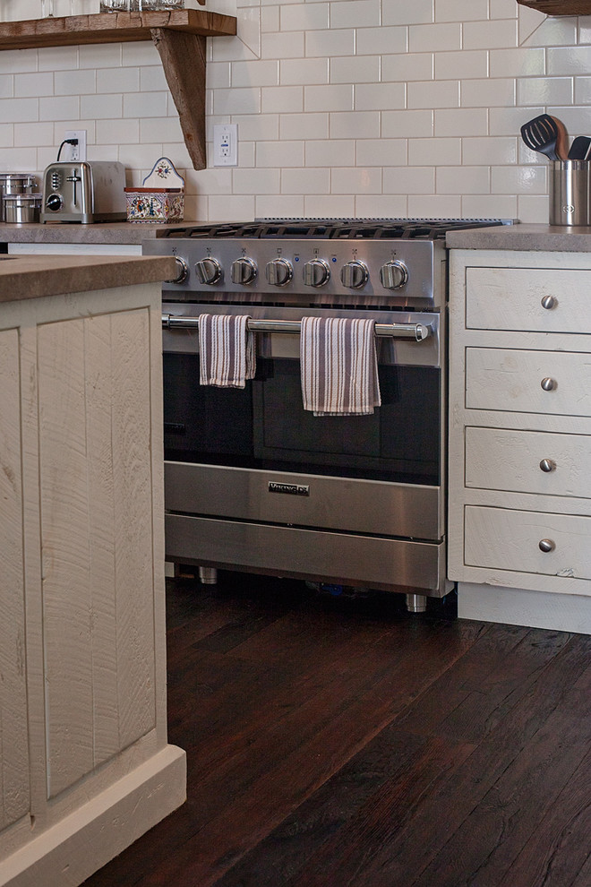 Foto di una cucina chic di medie dimensioni con ante lisce, ante bianche, elettrodomestici in acciaio inossidabile e parquet scuro
