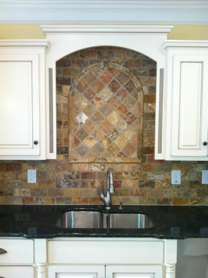 Klassisk inredning av ett avskilt u-kök, med luckor med upphöjd panel, skåp i slitet trä, granitbänkskiva, beige stänkskydd, stänkskydd i stenkakel, en köksö och en dubbel diskho