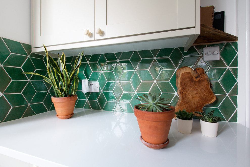Стильный дизайн: прямая кухня-гостиная среднего размера в стиле неоклассика (современная классика) с зеленым фартуком, фартуком из керамической плитки и полом из керамогранита - последний тренд