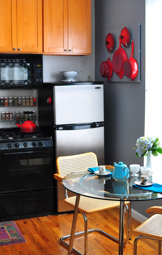 Eclectic single-wall eat-in kitchen photo in New York with shaker cabinets, medium tone wood cabinets and stainless steel appliances