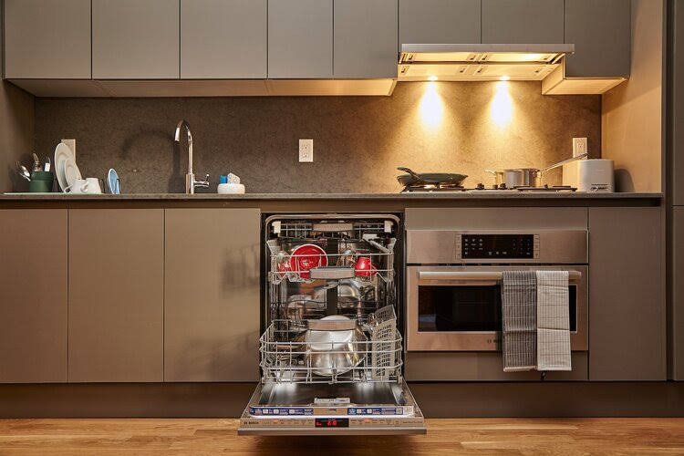 Large contemporary single-wall kitchen/diner in New York with a submerged sink, flat-panel cabinets, grey cabinets, terrazzo worktops, grey splashback, stone slab splashback, stainless steel appliances, medium hardwood flooring, no island, brown floors and grey worktops.