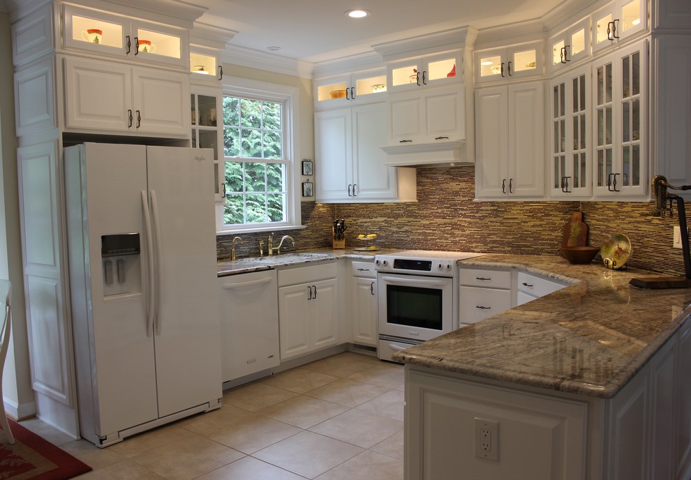 Exemple d'une cuisine chic en U de taille moyenne avec des portes de placard blanches, un plan de travail en granite, une crédence marron, un électroménager blanc, un sol en carrelage de céramique et un évier 2 bacs.