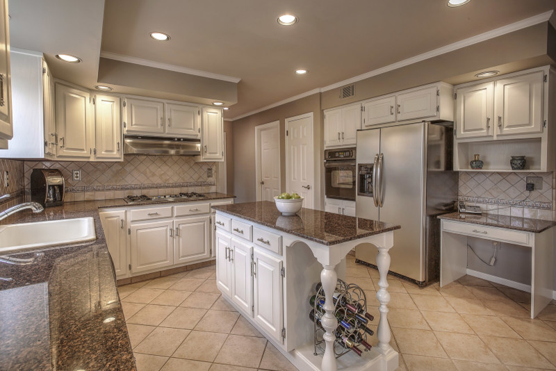 Exempel på ett avskilt klassiskt kök, med en nedsänkt diskho, luckor med upphöjd panel, vita skåp, granitbänkskiva, flerfärgad stänkskydd, stänkskydd i keramik, rostfria vitvaror, klinkergolv i keramik och en köksö