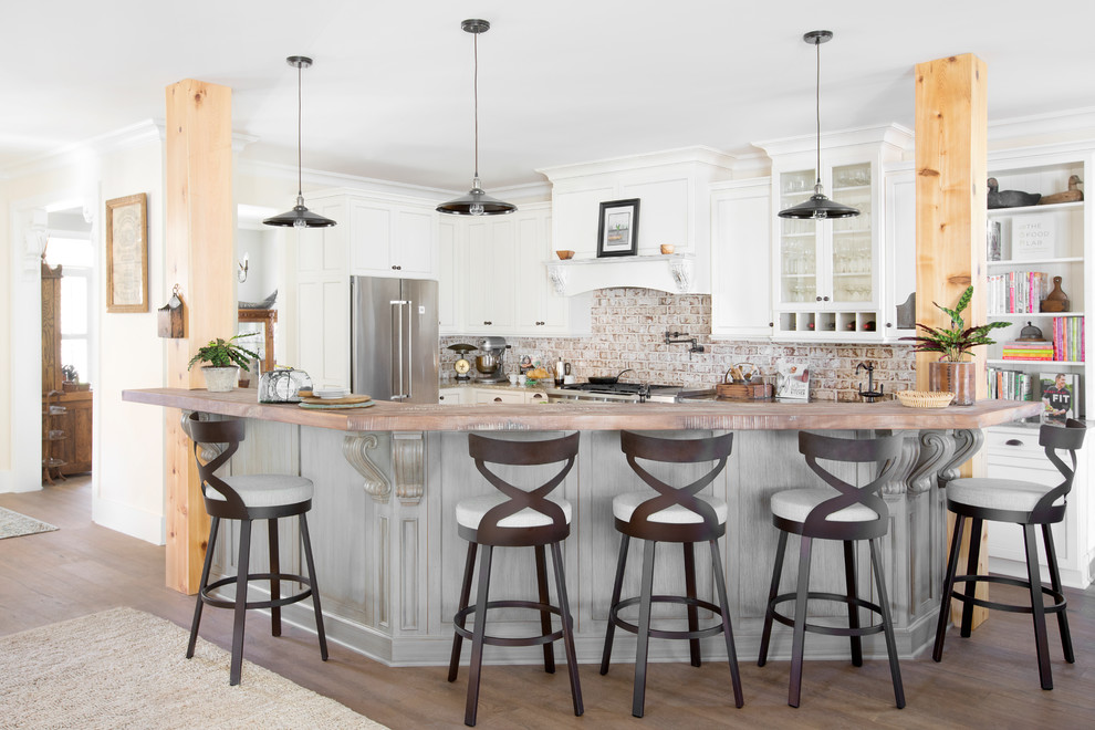 Inspiration for a rural u-shaped kitchen in Charleston with shaker cabinets, white cabinets, brick splashback, stainless steel appliances, dark hardwood flooring, an island, brown floors and red splashback.