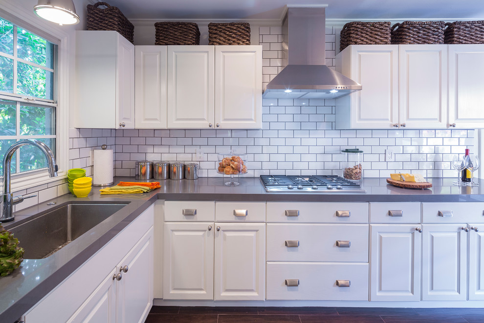 Example of a transitional enclosed kitchen design in Los Angeles with an undermount sink, recessed-panel cabinets, white cabinets, white backsplash, subway tile backsplash, stainless steel appliances and no island