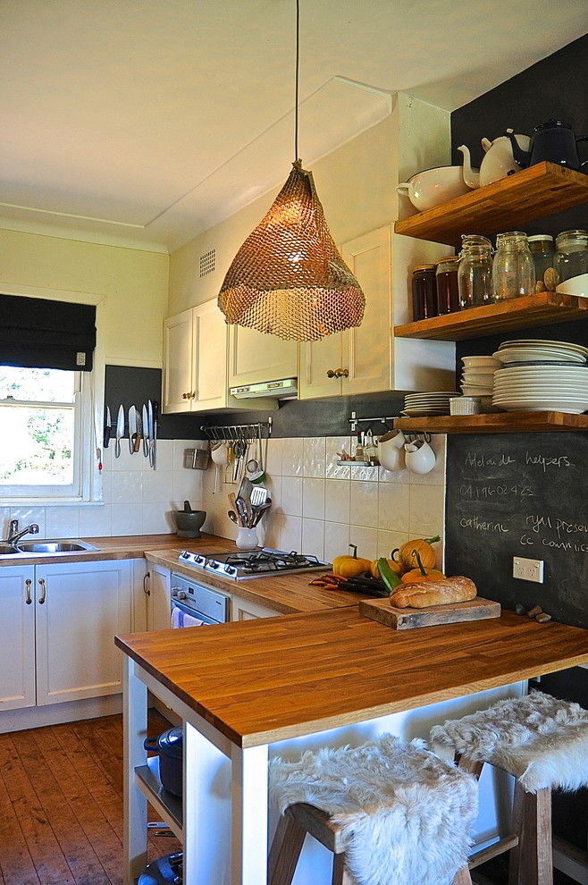 Urige Küche in U-Form mit Doppelwaschbecken, offenen Schränken, hellbraunen Holzschränken, Arbeitsplatte aus Holz, Küchenrückwand in Weiß, Küchengeräten aus Edelstahl und braunem Holzboden in Adelaide