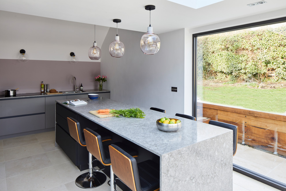 Exempel på ett mellanstort modernt grå grått l-kök, med släta luckor, svarta skåp, bänkskiva i kvartsit, rosa stänkskydd och en köksö
