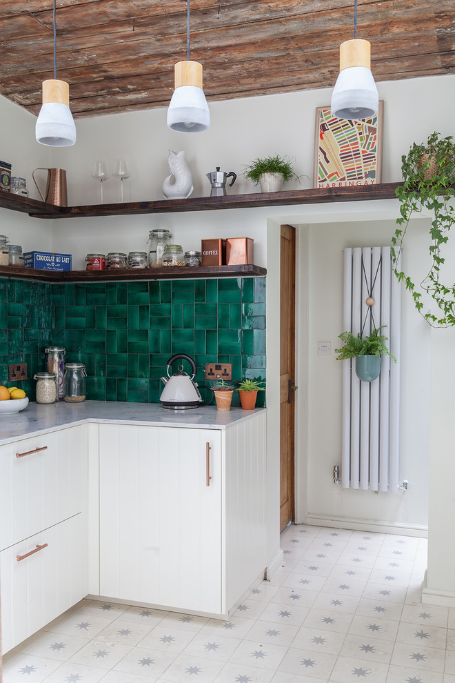 Small bohemian l-shaped enclosed kitchen in London with an integrated sink, shaker cabinets, white cabinets, marble worktops, green splashback, ceramic splashback, integrated appliances, cement flooring, no island and white floors.