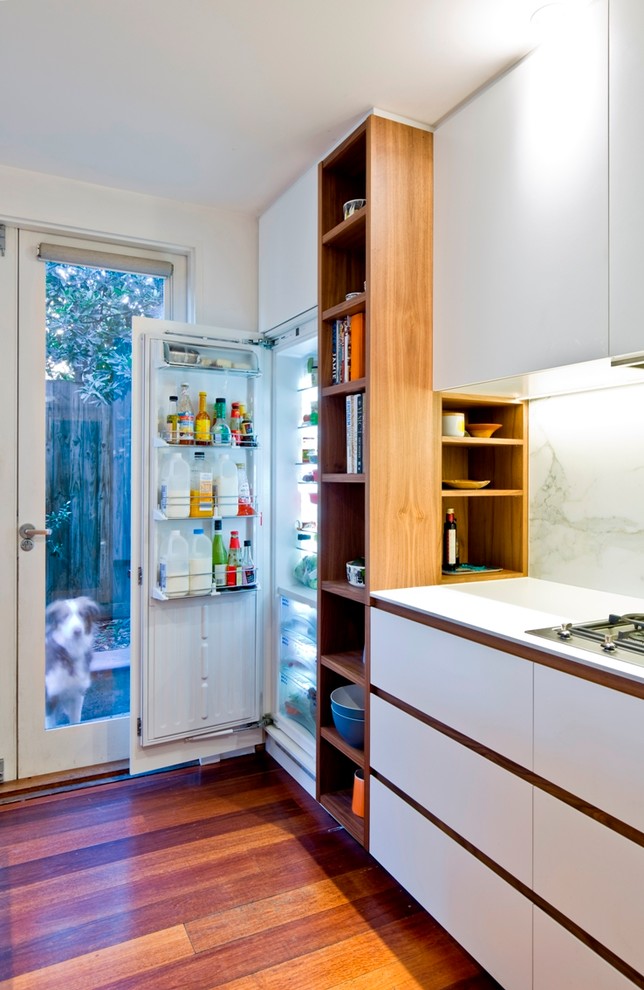Idée de décoration pour une cuisine américaine design en U et bois foncé de taille moyenne avec un évier 2 bacs, une crédence blanche, une crédence en dalle de pierre, un électroménager en acier inoxydable, parquet foncé et îlot.