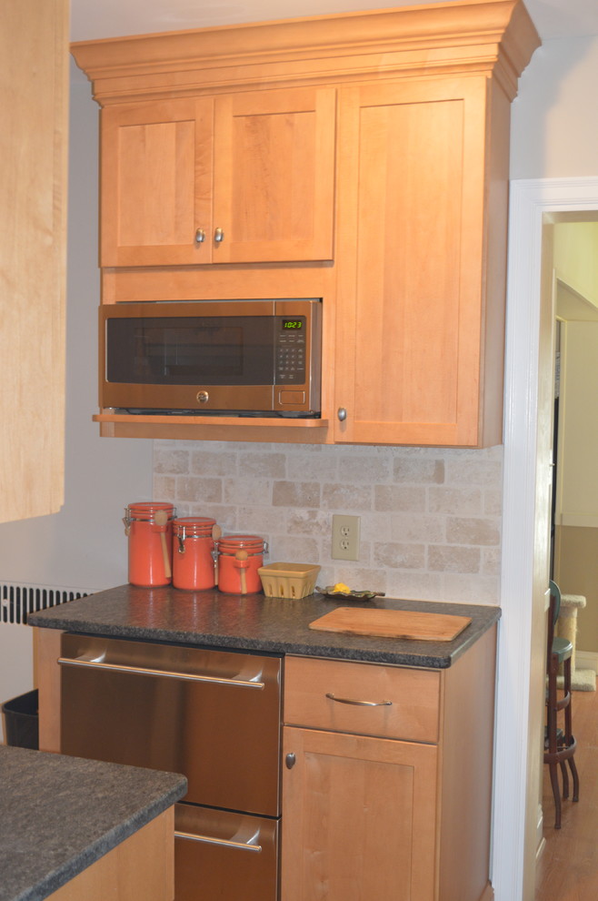Exempel på ett avskilt, litet klassiskt linjärt kök, med en enkel diskho, skåp i shakerstil, skåp i ljust trä, granitbänkskiva, beige stänkskydd, stänkskydd i tunnelbanekakel, rostfria vitvaror och korkgolv