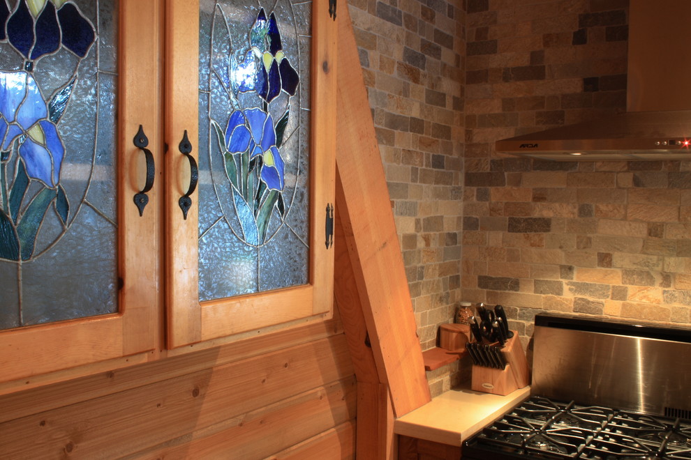 Idée de décoration pour une cuisine américaine parallèle tradition en bois clair avec un évier posé, un placard à porte shaker, un plan de travail en quartz modifié, un électroménager en acier inoxydable et îlot.