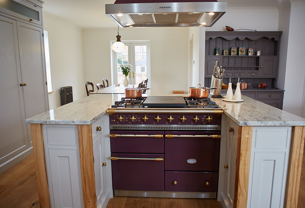 Idéer för att renovera ett stort vintage vit vitt kök, med en rustik diskho, skåp i shakerstil, lila skåp, granitbänkskiva, färgglada vitvaror, mellanmörkt trägolv, en köksö och brunt golv