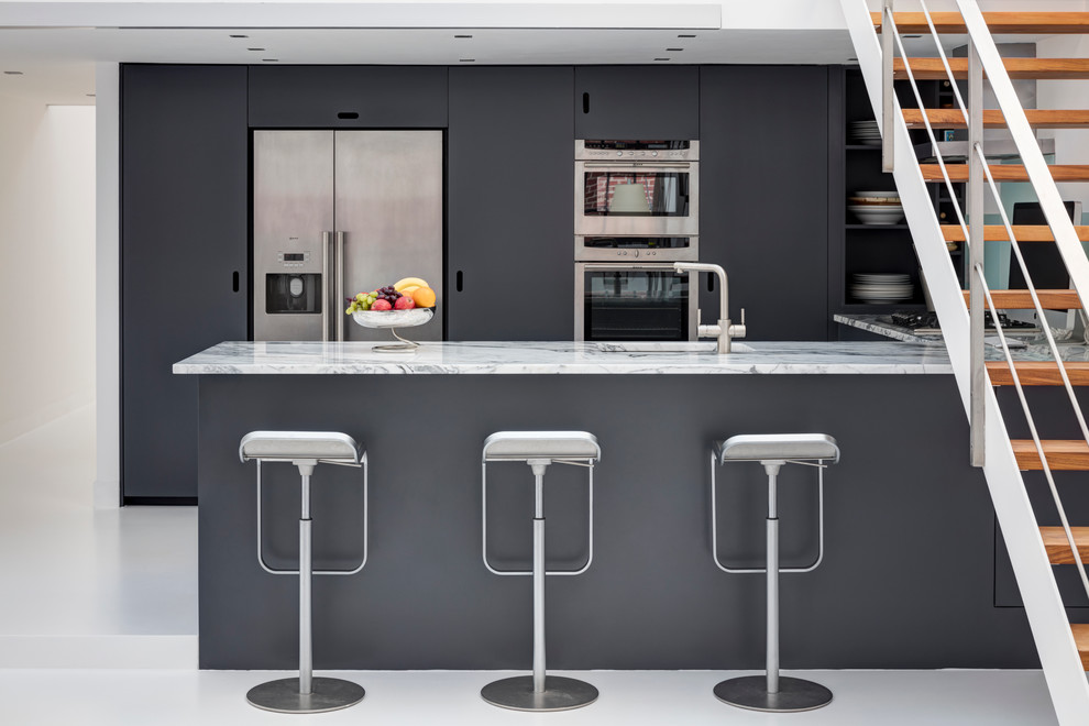 Свежая идея для дизайна: кухня в современном стиле с врезной мойкой, плоскими фасадами, черными фасадами и техникой из нержавеющей стали - отличное фото интерьера