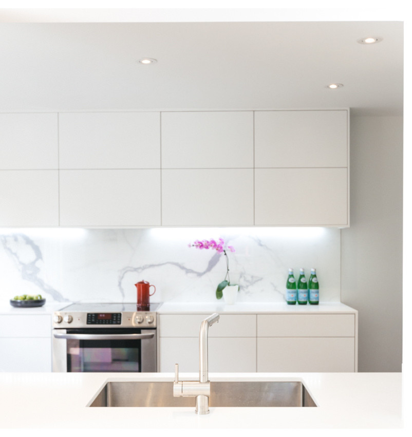 Foto på ett mellanstort minimalistiskt kök, med en undermonterad diskho, släta luckor, vita skåp, vitt stänkskydd, stänkskydd i marmor, rostfria vitvaror, mörkt trägolv och brunt golv