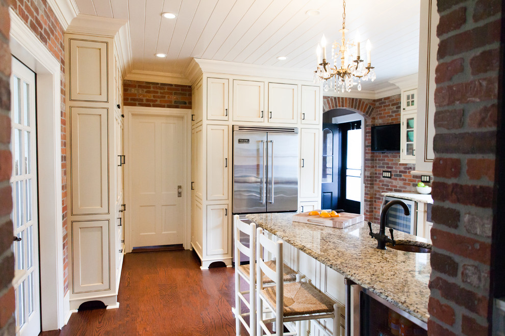 Inspiration for a huge cottage u-shaped medium tone wood floor eat-in kitchen remodel in New York with a farmhouse sink, white cabinets, granite countertops, red backsplash, stainless steel appliances, no island, beaded inset cabinets and brick backsplash