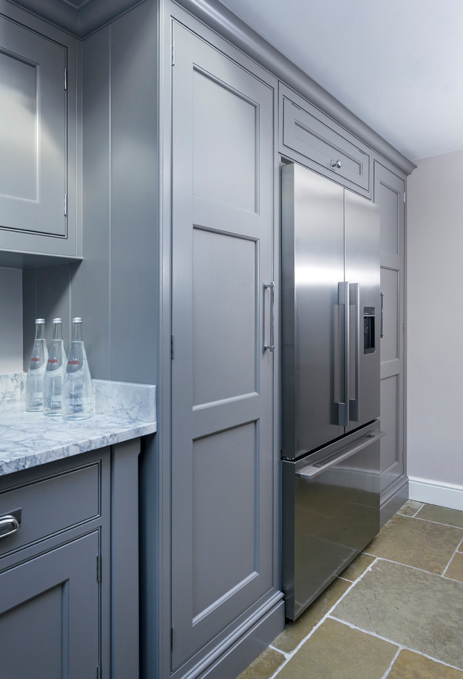 Small traditional galley kitchen/diner in Hampshire with a double-bowl sink, flat-panel cabinets, grey cabinets, marble worktops, mirror splashback, stainless steel appliances, limestone flooring, no island and beige floors.