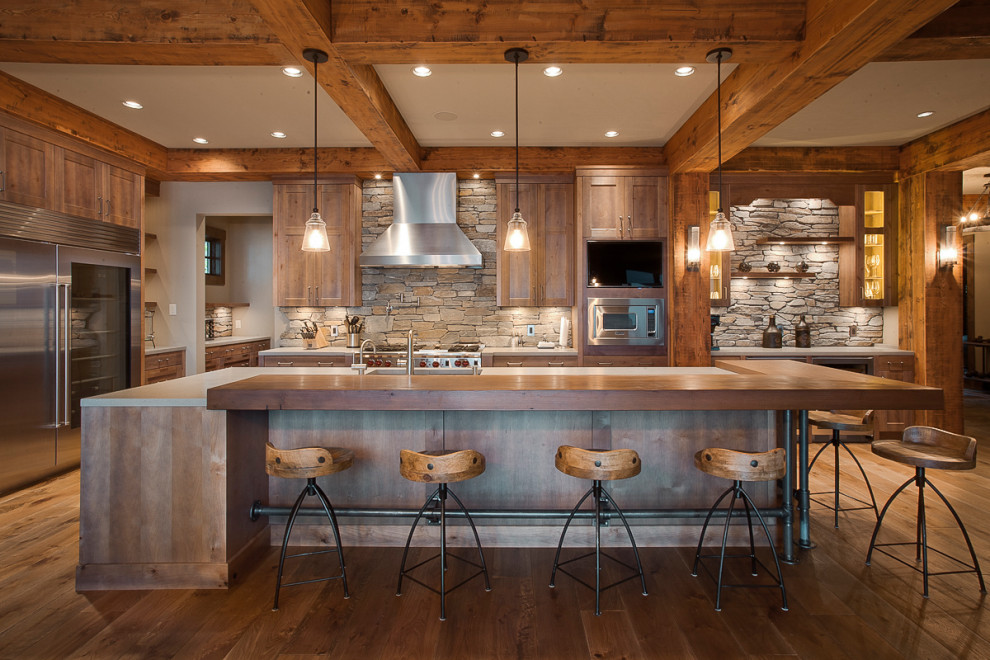 Inspiration for a large rustic u-shaped medium tone wood floor, brown floor and exposed beam eat-in kitchen remodel in Vancouver with shaker cabinets, medium tone wood cabinets, wood countertops, gray backsplash, stone tile backsplash, stainless steel appliances and an island