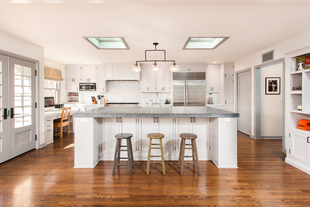 Elegant medium tone wood floor kitchen photo in Los Angeles with stainless steel appliances, shaker cabinets and white cabinets
