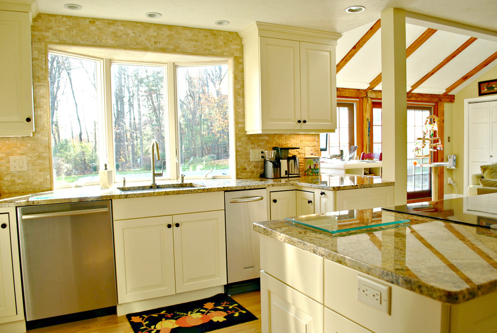 Inspiration for a mid-sized timeless l-shaped light wood floor eat-in kitchen remodel in Boston with an undermount sink, raised-panel cabinets, white cabinets, granite countertops, beige backsplash, stone tile backsplash, stainless steel appliances and an island