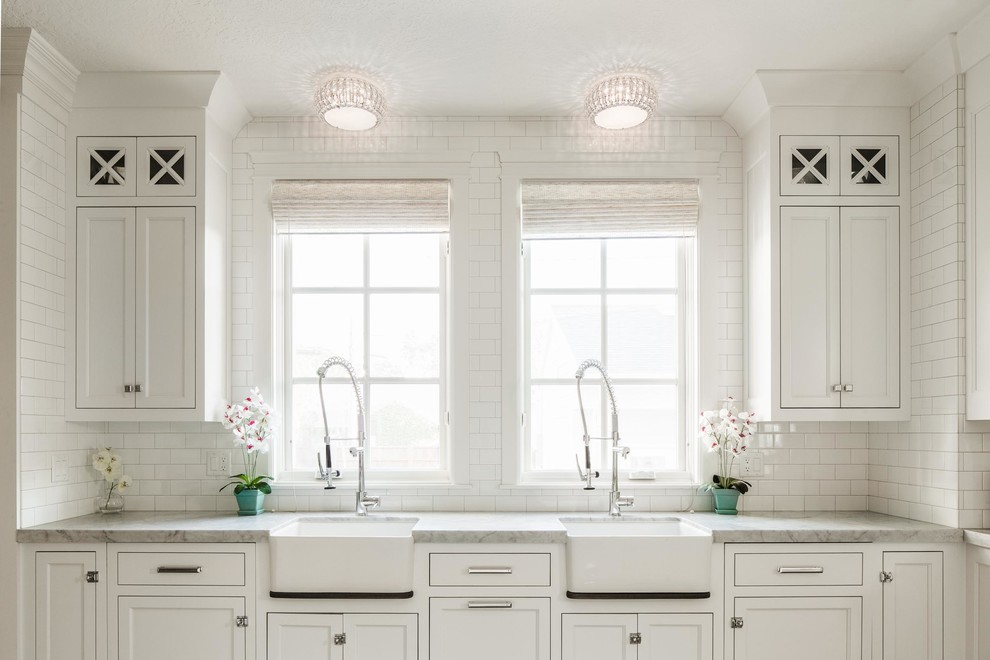 Foto på ett vintage kök och matrum, med en rustik diskho, luckor med infälld panel, vita skåp, vitt stänkskydd, stänkskydd i tunnelbanekakel, marmorbänkskiva och integrerade vitvaror