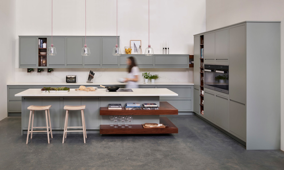 Inredning av ett modernt mellanstort kök, med släta luckor, grå skåp, bänkskiva i kvartsit, vitt stänkskydd, stänkskydd i marmor, betonggolv, en halv köksö och grått golv