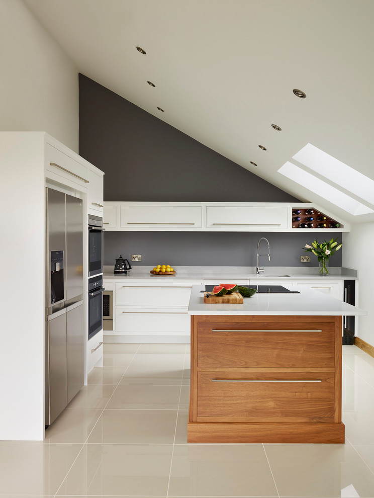 Moderne Küche in L-Form mit flächenbündigen Schrankfronten, weißen Schränken, Küchengeräten aus Edelstahl und Kücheninsel in London
