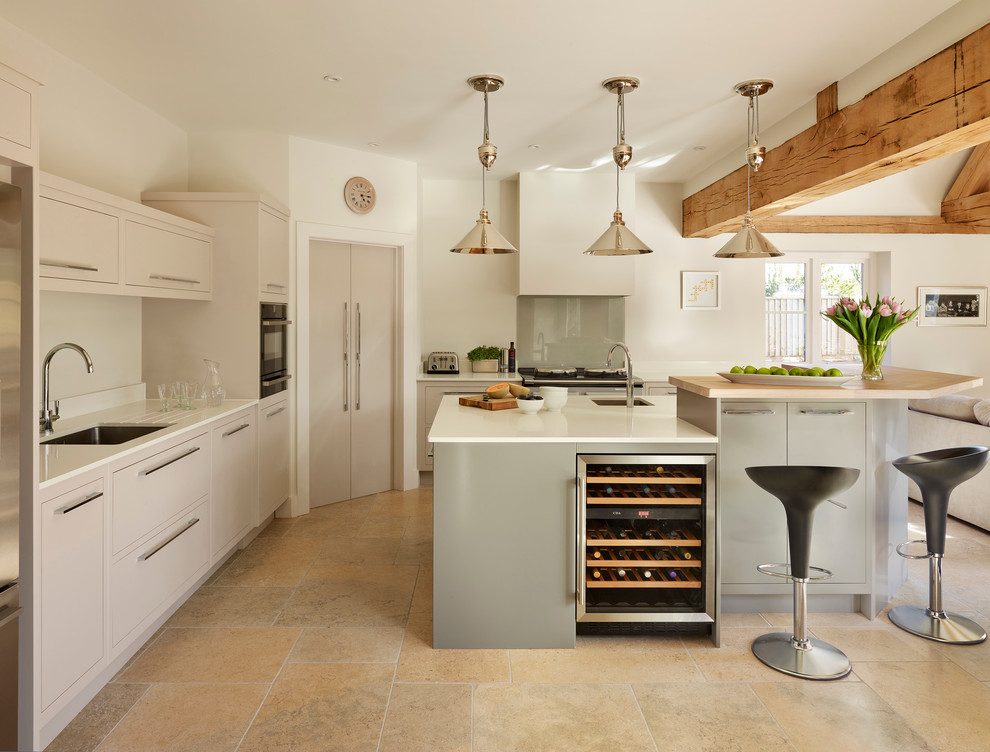 Offene Moderne Küche in L-Form mit Unterbauwaschbecken, flächenbündigen Schrankfronten, grauen Schränken, Küchenrückwand in Grau, Glasrückwand und Kücheninsel in London