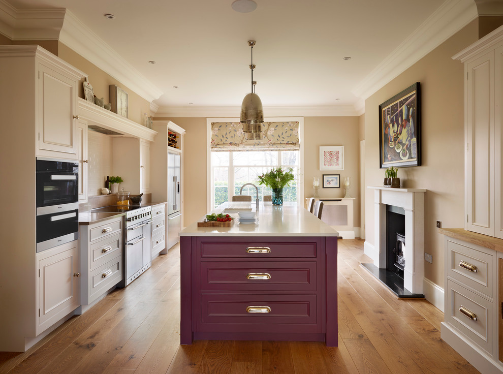 Foto di una cucina classica con lavello sottopiano, ante a filo, ante rosse e pavimento in legno massello medio