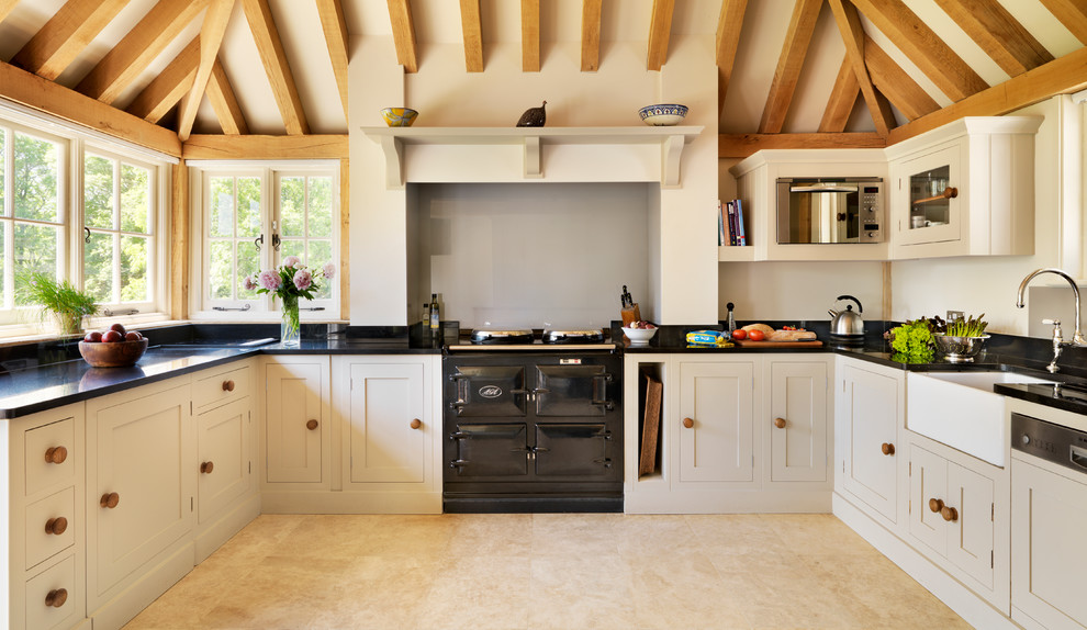Landhausstil Küche in U-Form mit Landhausspüle, Schrankfronten im Shaker-Stil, grauen Schränken, Küchenrückwand in Grün, Glasrückwand und schwarzen Elektrogeräten in London