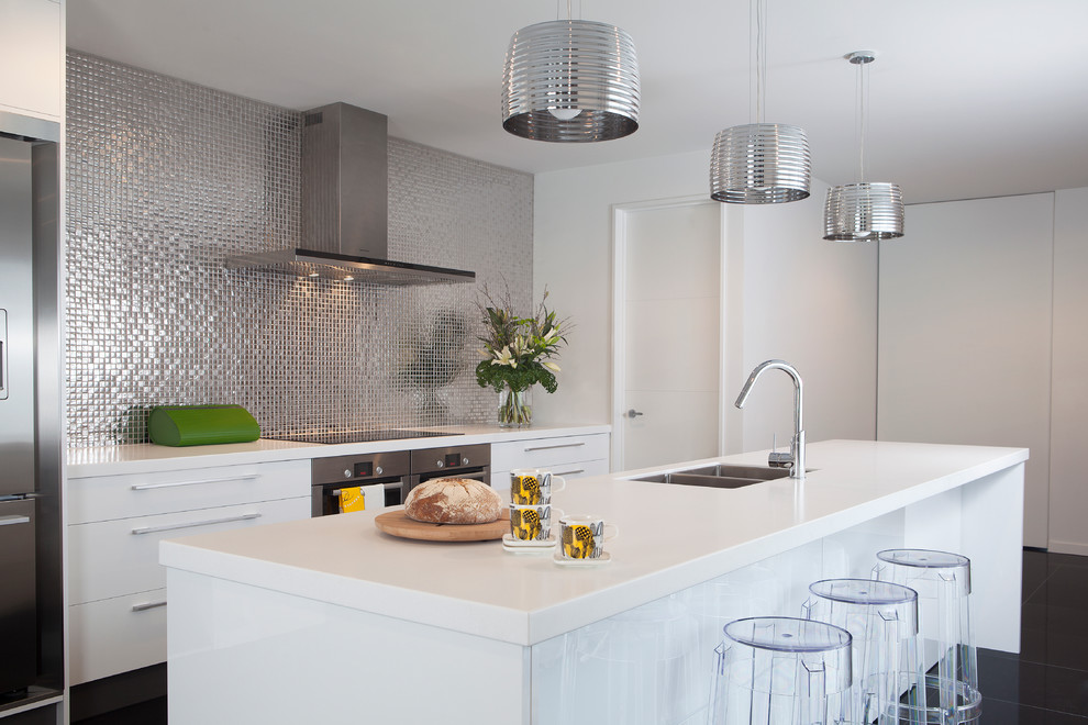 Eat-in kitchen - mid-sized modern single-wall eat-in kitchen idea in Christchurch with an undermount sink, flat-panel cabinets, yellow cabinets, gray backsplash, stainless steel appliances and an island