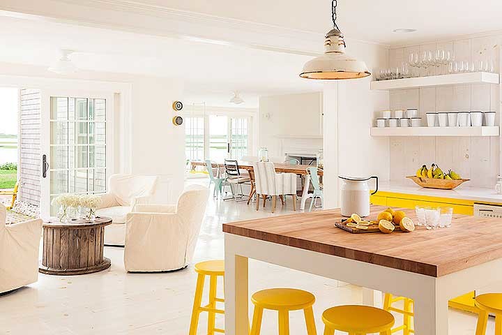 Foto de cocina ecléctica grande con puertas de armario amarillas, encimera de madera, salpicadero blanco, salpicadero de madera, electrodomésticos blancos y una isla