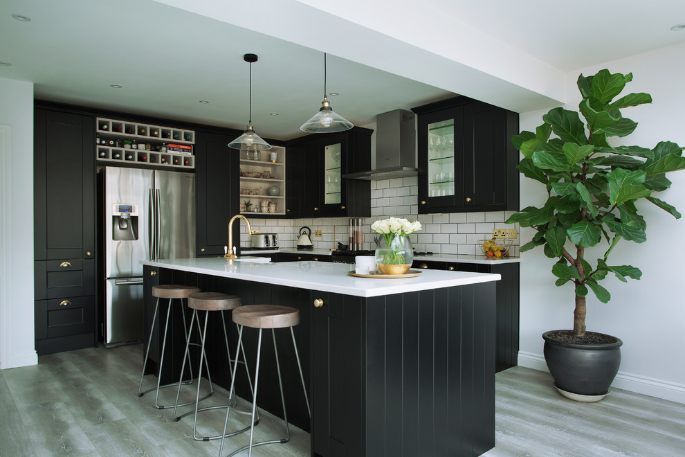 Inspiration for a large contemporary ceramic tile and gray floor eat-in kitchen remodel in London with a farmhouse sink, recessed-panel cabinets, black cabinets, quartzite countertops, white backsplash, stainless steel appliances and an island
