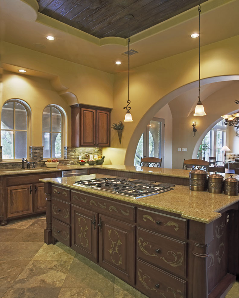 Example of a tuscan kitchen design in Austin with raised-panel cabinets, dark wood cabinets and gray backsplash