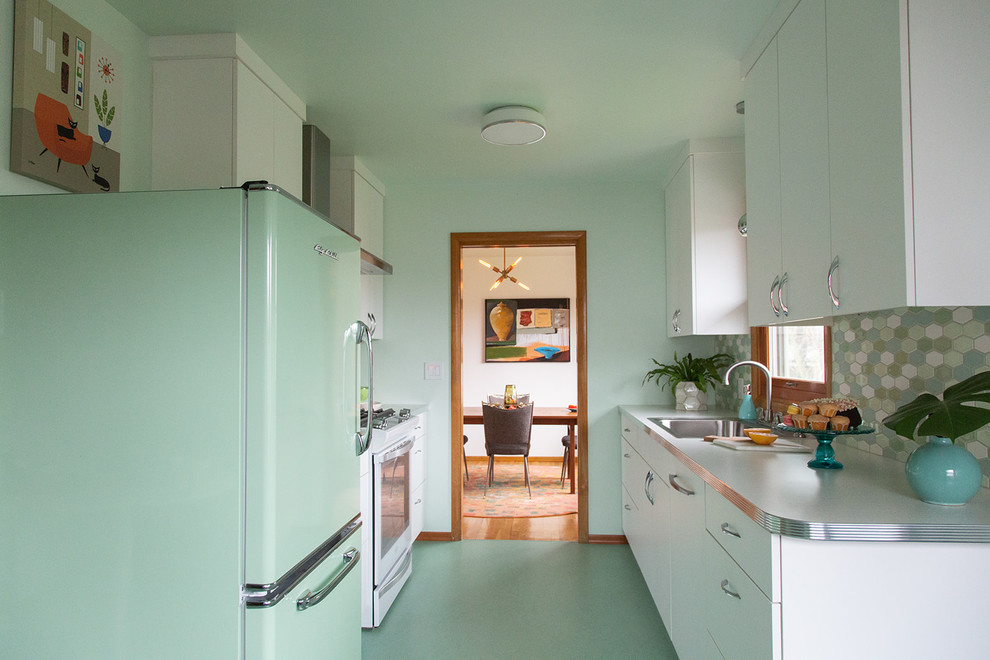 ポートランドにある小さなミッドセンチュリースタイルのおしゃれなキッチン (ドロップインシンク、フラットパネル扉のキャビネット、白いキャビネット、ラミネートカウンター、マルチカラーのキッチンパネル、セラミックタイルのキッチンパネル、カラー調理設備、リノリウムの床、アイランドなし、緑の床、白いキッチンカウンター) の写真