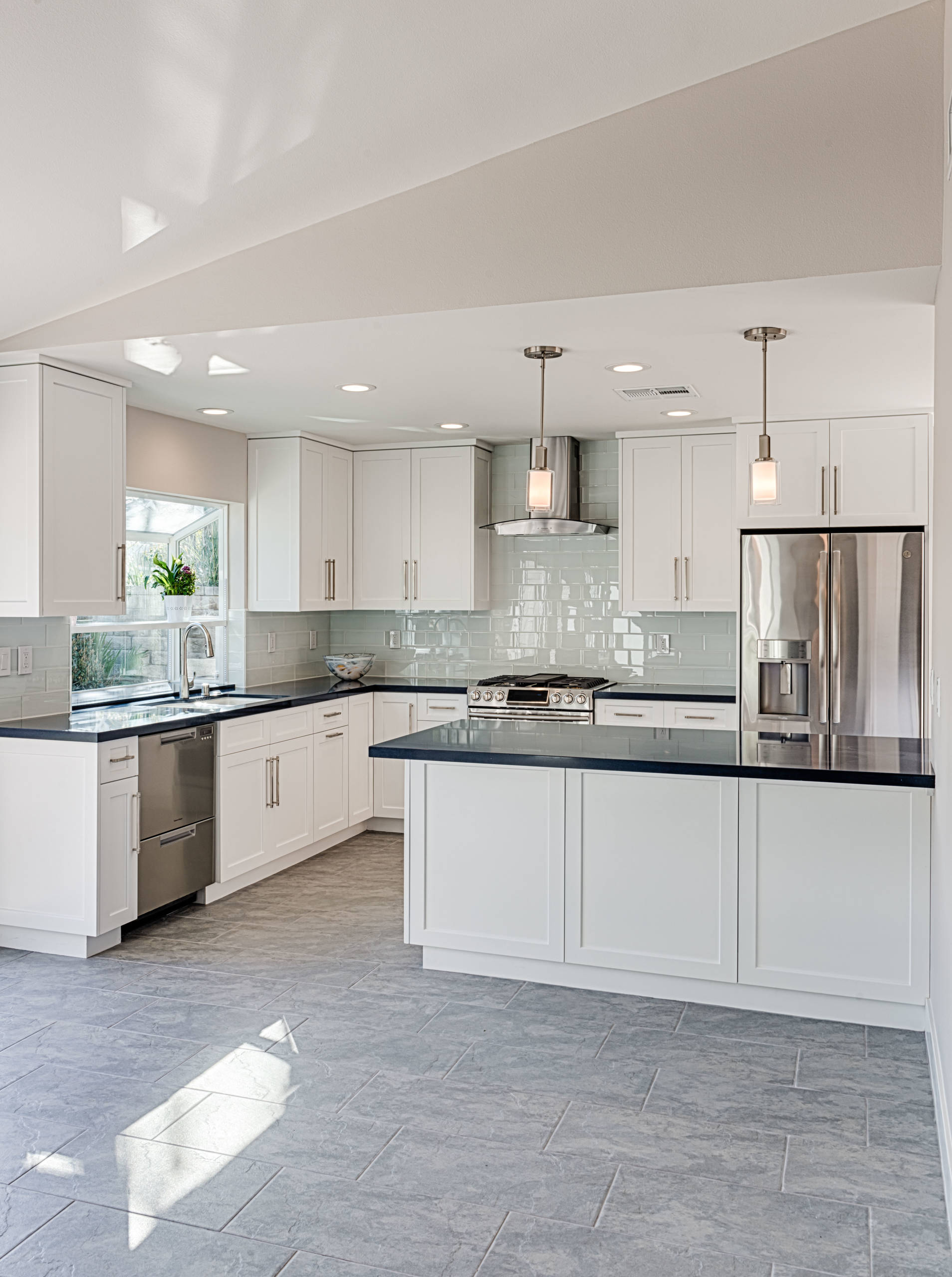 Cocina de diseño con encimera de cuarzo con efecto cascada en la isla.