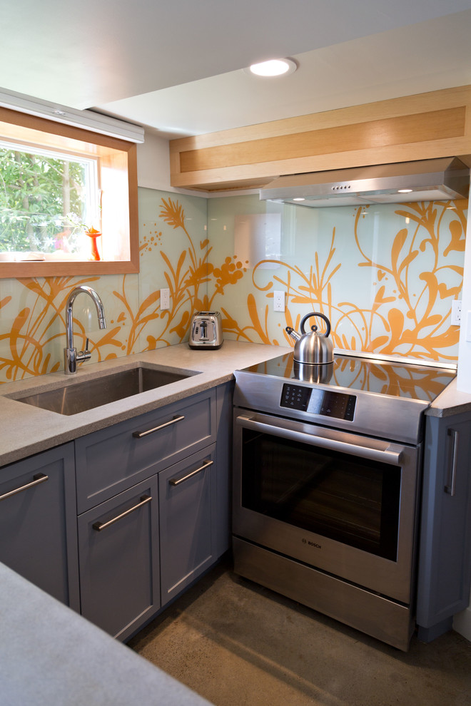 Example of a small minimalist u-shaped concrete floor and gray floor eat-in kitchen design in Portland with an undermount sink, shaker cabinets, gray cabinets, concrete countertops, multicolored backsplash, glass sheet backsplash, stainless steel appliances, no island and gray countertops