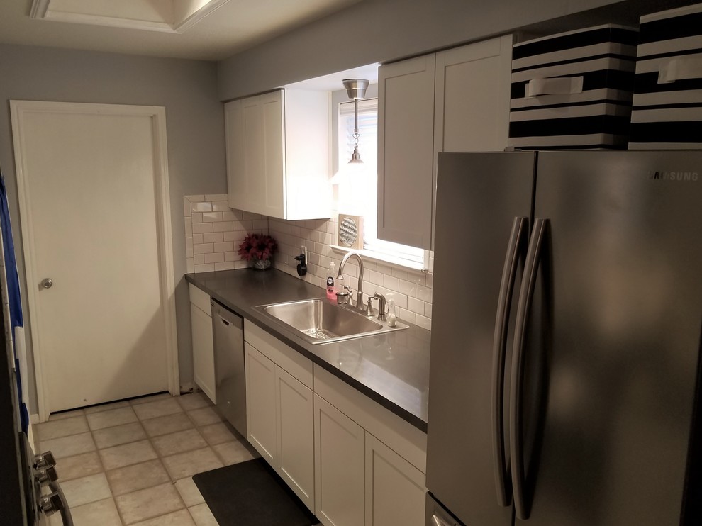 Bild på ett litet funkis grå grått kök, med en nedsänkt diskho, skåp i shakerstil, vita skåp, bänkskiva i kvarts, vitt stänkskydd, stänkskydd i tunnelbanekakel, rostfria vitvaror, klinkergolv i keramik och grått golv