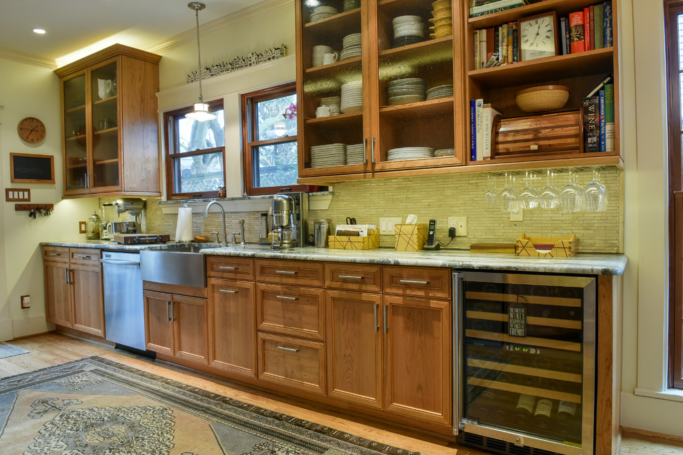 Diseño de cocina tradicional renovada, cerrada, sin isla, con fregadero sobremueble, puertas de armario de madera oscura, encimera de granito, salpicadero beige, salpicadero de azulejos de piedra, electrodomésticos de acero inoxidable, suelo de madera en tonos medios y armarios con paneles empotrados