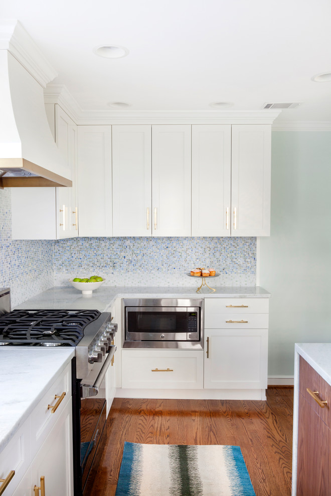 Ejemplo de cocina clásica renovada pequeña con fregadero bajoencimera, puertas de armario blancas, encimera de cuarcita, salpicadero azul, salpicadero con mosaicos de azulejos, suelo de madera en tonos medios y una isla