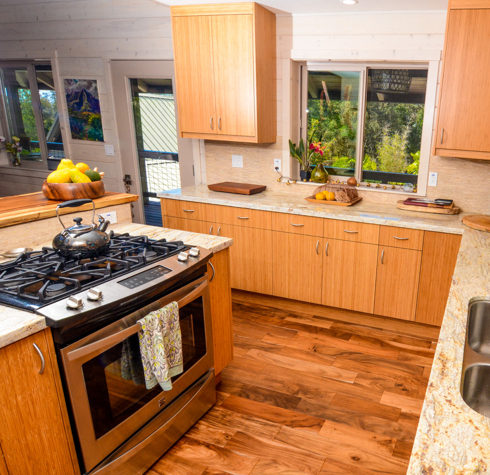 Foto på ett mellanstort tropiskt kök, med släta luckor, skåp i ljust trä, granitbänkskiva, beige stänkskydd, stänkskydd i keramik, rostfria vitvaror, mellanmörkt trägolv och en köksö