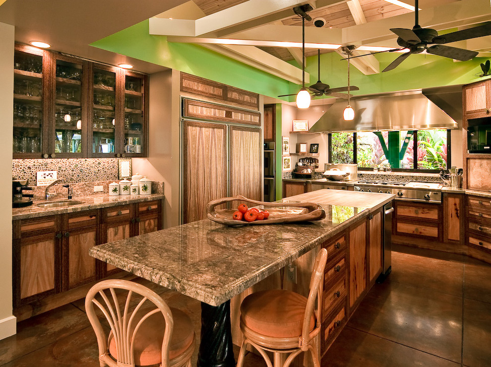 ハワイにあるトロピカルスタイルのおしゃれな独立型キッチン (ガラス扉のキャビネット、中間色木目調キャビネット、パネルと同色の調理設備) の写真
