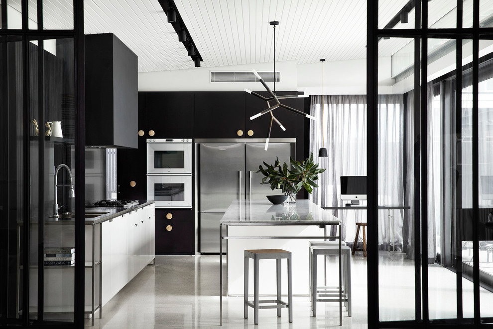Свежая идея для дизайна: угловая кухня в современном стиле с плоскими фасадами, черными фасадами, техникой из нержавеющей стали и островом - отличное фото интерьера
