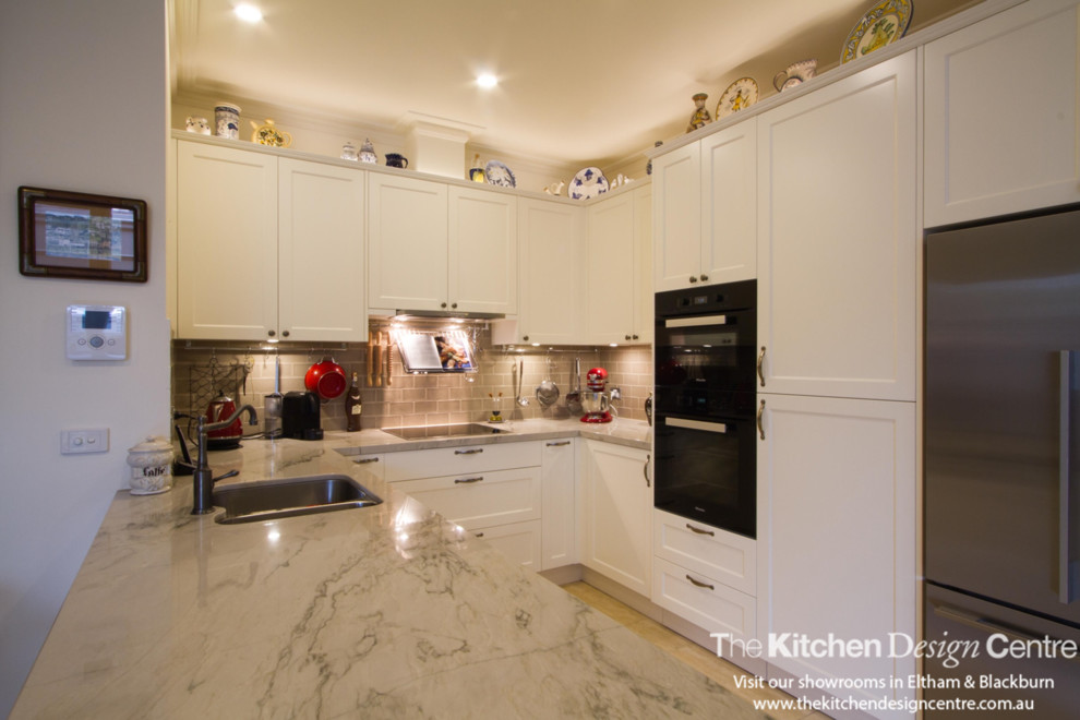 Immagine di una piccola cucina classica con ante in stile shaker, ante bianche, top in granito, pavimento in gres porcellanato e penisola