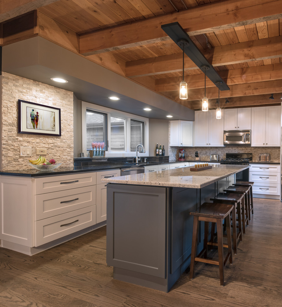 Idées déco pour une cuisine américaine montagne avec un plan de travail en granite, une crédence multicolore, un sol en bois brun et îlot.