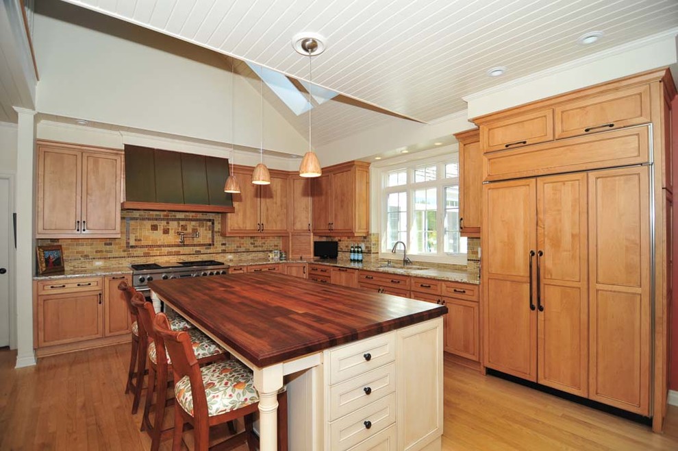 Exempel på ett stort lantligt flerfärgad flerfärgat l-kök, med en undermonterad diskho, integrerade vitvaror, mellanmörkt trägolv, brunt golv, luckor med infälld panel, skåp i mellenmörkt trä, granitbänkskiva, flerfärgad stänkskydd, stänkskydd i stenkakel och en köksö