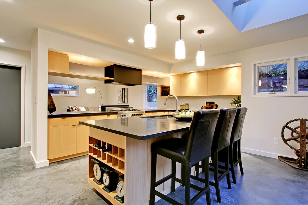 Foto di una cucina minimal di medie dimensioni con lavello sottopiano, ante lisce, ante in legno chiaro, top in quarzo composito, elettrodomestici in acciaio inossidabile e pavimento in cemento
