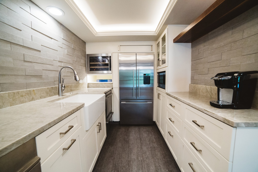 Inspiration for a small transitional galley ceramic tile enclosed kitchen remodel in Seattle with an undermount sink, shaker cabinets, white cabinets, quartzite countertops, beige backsplash, ceramic backsplash, stainless steel appliances and no island