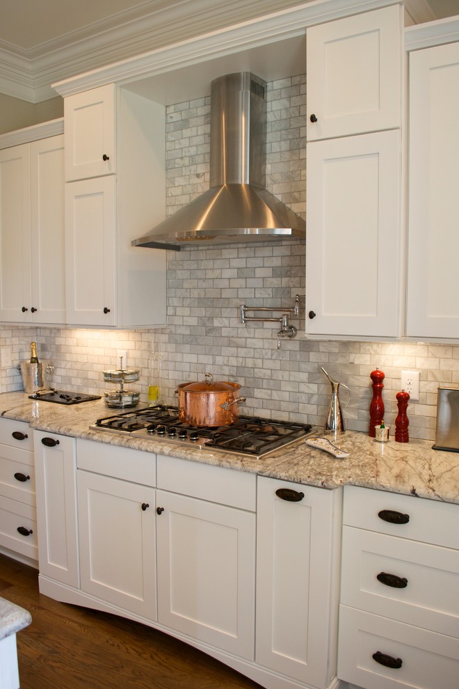 Klassisk inredning av ett mellanstort, avskilt kök, med en rustik diskho, skåp i shakerstil, vita skåp, granitbänkskiva, grått stänkskydd, stänkskydd i stenkakel, rostfria vitvaror, mellanmörkt trägolv och en köksö